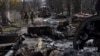 Soldiers walk amid destroyed Russian tanks in Bucha, in the outskirts of Kyiv, Ukraine, April 3, 2022. (AP Photo/Rodrigo Abd, File)