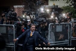 An unidentified man tries to hold back the press as Saudi investigators arrive at the Saudi Arabian Consulate in Istanbul, Turkey, amid a growing international backlash to the disappearance of journalist Jamal Khashoggi.