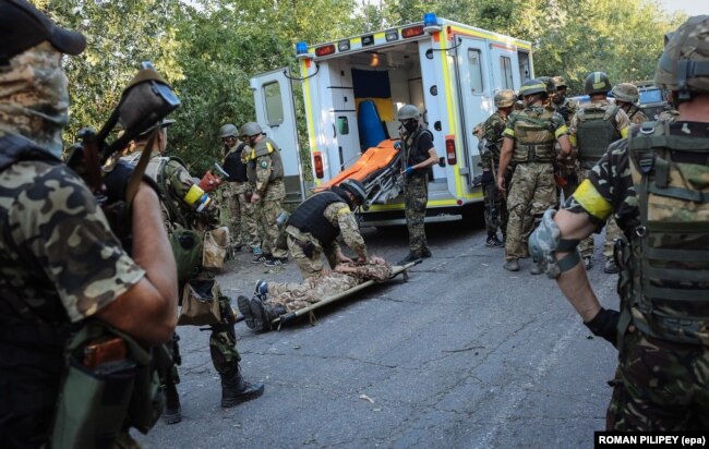 UKRAINE – Ukrainian soldiers rescue an injured comrade during fighting against militants, close to Ilovaysk, near Donetsk, August 10, 2014.