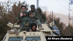 Members of Taliban sit on a military vehicle during Taliban military parade in Kabul, November 14, 2021. (Ali Khara/Reuters)