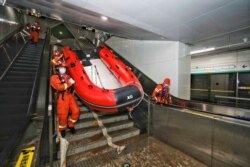 Rescue workers enter a subway station of Metro Line 5 to inspect the floodwaters following heavy rainfall in Zhengzhou, Henan province, on July 26, 2021. (Source: China Daily via Reuters)