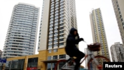 A woman cycles past a building registered to Huaying Haitai Science and Technology Development Co. in Tianjin, China, the alleged employer of two Chinese nationals indicted by the United States on hacking charges on December 21, 2018. (Reuters)