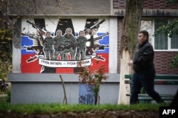 A pedestrian walks past a mural depicting Russia's paramilitary 'Wagner Group,' which reads, "Wagner Group - Russian knights," in Belgrade, on November 17, 2022. (Oliver Bunic/AFP)