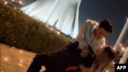 This image grab taken from a UGC video posted on Twitter on Jan. 29, 2023, shows Astiyazh Haghighi and her fiance Amir Mohammad Ahmadi dancing in front of Tehran's Azadi Tower. (AFP/ESN/HENGAW)