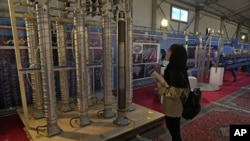 A student looks at Iran's domestically built centrifuges in an exhibition of the country's nuclear achievements, in Tehran, Iran on February 8, 2023. (Vahid Salemi/AP)
