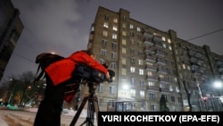 A cameraman works in front of the building housing an office of the German Deutsche Welle TV channel in Moscow, Russia, February 3, 2022. The Russian Foreign Ministry said the Moscow office of Deutsche Welle must close. (Yuri Kochetkov/EPA-EFE)