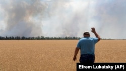 A farmer reacts as he looks at his burning field caused by the fighting at the front line in the Dnipropetrovsk region, Ukraine, Monday, July 4, 2022. (Efrem Lukatsky/AP)