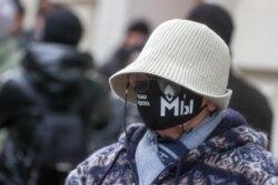 A woman in a face covering with messages reading "There Is No Way To Ban Memorial" and "We" is seen outside the Supreme Court of Russia during a hearing to consider a bid by the Russian Prosecutor General’s Office to close down Memorial on December 14. (TASS/Stanislav Krasilnikov)