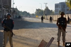 Security officials guard a blocked road leading to a counter-terrorism center after security forces started to clear the compound seized earlier by Pakistani Taliban militants in Bannu, a northern district in Khyber Pakhtunkhwa province, on December 20, 2022. (Muhammad Hasib/AP)