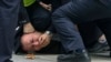 Policemen pin down and arrest a protester during a protest on a street in Shanghai, China, Sunday, Nov. 27, 2022.