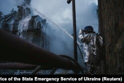 A firefighter extinguishes a blaze at a critical power infrastructure site hit during Russian drone attacks in Kyiv on December 19, 2022. (State Emergency Service of Ukraine/via Reuters)