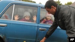 Children look through car windows as they and other refugees from Ukraine's Kharkiv Region come to a temporary camp in Belgorod, Russia, on September 14, 2022. (Associated Press)