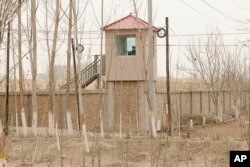 A security guard watches from a tower around a detention facility in Yarkent County, the Xinjiang Uyghur Autonomous Region, on March 21, 2021. (Ng Han Guan/Associated Press)