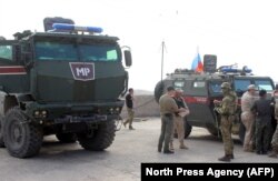 SYRIA -- Russian military police troops stand next to their armored vehicles in the northeastern Syrian city of Kobani, October 23, 2019
