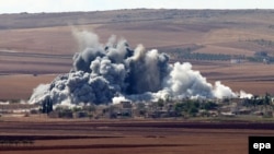 Syria -- Smoke rises after an apparent US-led coalition airstrike on Minaze village near Kobani, October 15, 2014