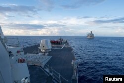The Arleigh Burke-class guided-missile destroyer USS Dewey prepares for a replenishment-at-sea in the South China Sea on May 19, 2017.