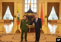 In this Jan. 12, 2021, file photo provided by Myanmar Military Information Team, Myanmar's Army Commander Senior Gen. Min Aung Hlaing, left, and Chinese Foreign Minister Wang Yi pose for a photo during their meeting in Naypyitaw, Myanmar.