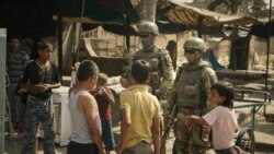 Russian soldiers escorting a group of journalists stand guard as children gather in Deir ez-Zor, September 15, 2017.