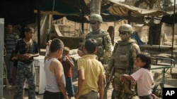 Russian soldiers escorting a group of journalists stand guard as children gather in Deir ez-Zor, September 15, 2017.