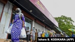 People queue outside a state-run supermarket to buy essential food items in Colombo on September 3, 2021, as Sri Lanka began imposing price controls on essential food under a state of emergency. (Ishara S. Kodikara / AFP)
