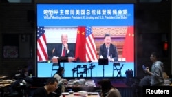A screen at a restaurant in Beijing shows Chinese President Xi Jinping attending a virtual meeting with U.S. President Joe Biden via video link on November 16, 2021. (Tingshu Wang/Reuters)