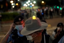 A man wearing a hat with an LED candle at Victoria Park on June 4, 2022. A large police force patrolled the park after authorities banned commemorations of the 1989 Tiananmen massacre in Beijing for the third year straight. (Associated Press)