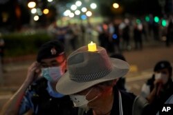 A man wearing a hat with an LED candle at Victoria Park on June 4, 2022. A large police force patrolled the park after authorities banned commemorations of the 1989 Tiananmen massacre in Beijing for the third year straight. (Associated Press)