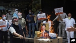 Indian traders burn Chinese products and a poster of Chinese President Xi Jinping during a protest in New Delhi on June 22, 2020, shortly after Chinese and Indian troops engaged in a deadly brawl along the Sino-Indian border. (Manish Swarup/AP)