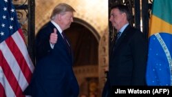 U.S. – U.S. President Donald Trump (L) speaks with Brazilian President Jair Bolsonaro during a dinner at Mar-a-Lago in Palm Beach, Florida. Taken on March 7, 2020