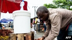 A man washes his hands with chlorinated water at the Mabibo market in Dar es Salaam, Tanzania, on April 16, 2020.