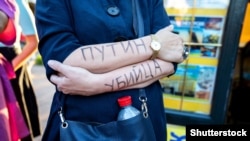 RUSSIA – A woman protests in support of Alexey Navalny with an inscription on her arms reading "Putin is a murderer." Saint Petersburg, August 21, 2020.