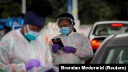 FILE PHOTO: Medical technicians work at a drive-through coronavirus disease (COVID-19) testing facility at the Regeneron Pharmaceuticals company's Westchester campus in Tarrytown, New York, U.S. September 17, 2020.