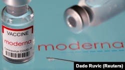 FILE PHOTO: Vial labeled "Moderna coronavirus disease (COVID-19) vaccine" placed on displayed Moderna logo is seen in this illustration picture taken March 24, 2021.