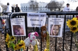 Pictures of Ukrainian children killed during Russia's invasion outside of the White House in Washington on March 5, 2022. (Jose Luis Magana/Associated Press)