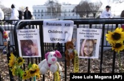 Pictures of Ukrainian children killed during Russia's invasion outside of the White House in Washington on March 5, 2022. (Jose Luis Magana/Associated Press)