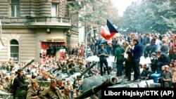 Prague citizens with a Czech flag surround a Soviet tank during as invading soldiers put down the "Prague Spring" movement on Aug 21, 1968 in Prague.