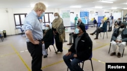 Britain's Prime Minister Boris Johnson talks to waiting patients as he visits a COVID-19 vaccination center in Batley, West Yorkshire, Britain February 1, 2021. Jon Super/Pool via REUTERS