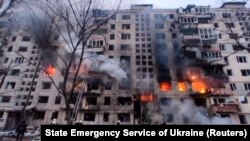 Rescuers work next to a residential building damaged by shelling, as Russia's attack on Ukraine continues, in Kyiv, March 14, 2022. (State Emergency Service of Ukraine/Reuters)