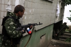 Pro-Russia militants fire from a residential building at Ukrainian border guards defending the Federal Border Headquarters in Luhansk on June 2, 2014.