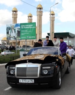 Chechnya -- Ramzan Kadyrov (R) rides in a Rolls-Royce Cabriolet as he escorts the Muslim relics, Prophet Muhammad's cup and carpets, from an airport to Grozny central mosque, Sep. 21, 2011.