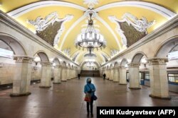 RUSSIA -- A person wearing protective mask stands in an almost deserted Komsomolskaya subway station in Moscow, April 3, 2020