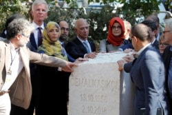 Hatice Cengiz, fiancee of the murdered Saudi journalist Jamal Khashoggi, and Jeff Bezos, founder of Amazon and Blue Origin, are flanked by attendees as they gather around a monument during a ceremony marking the first anniversary of Khashoggi's murder.