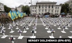 UKRAINE – Men in uniforms hold national flags near symbolic crosses with portraits of soldiers, who were lost near the village of Ilovaysk in eastern Ukraine in 2014, in front of Russian embassy in Kyiv, 29 August 2018