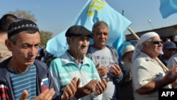 Crimean Tatars pray as they block the road at the checkpoint between continental Ukraine and occupied Crimea, in Chongar, September 20, 2015. (Genya Savilov/AFP)