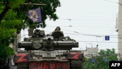 Members of Wagner group sit atop of a tank in a street in the city of Rostov-on-Don, on June 24, 2023. President Vladimir Putin said an armed mutiny by Wagner mercenaries was a "stab in the back" and that the group's chief Yevgeny Prigozhin had betrayed Russia. (AFP)