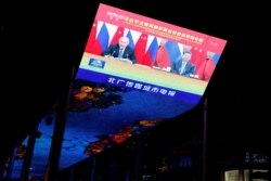 A giant screen broadcasts news footage of a virtual meeting between Chinese President Xi Jinping and Russian President Vladimir Putin, at a shopping mall in Beijing on December 15, 2021. (Carlos Garcia Rawlins/Reuters)