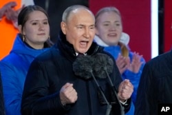Vladimir Putin gestures while addressing a crowd at a concert marking the 10-year anniversary of Russia's annexation of Crimea from Ukraine on Red Square in Moscow on March 18, 2024. (Alexander Zemlianichenko/AP)