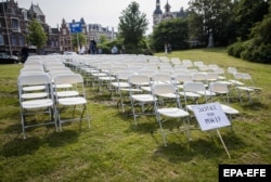 NETHERLANDS -- White chairs and a placard are set up by relatives of crash victims of flight MH17 as a silent protest in front of the Russian embassy in The Hague, May 8, 2018