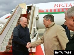 Belarusian President Alexander Lukashenko (L) is welcomed upon his arrival at a Moscow airport on April 22.
