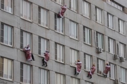 RUSSIA - Russian firemen and rescuers dressed in costumes of Father Frost (or Ded Moroz, or Santa Claus) descend along a wall from the roof of Morozovskaya Children's hospital.
